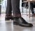Czarne buty męskie ze skóry eleganckie na nogach wizualizacja